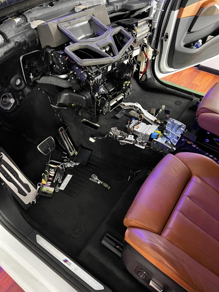 BMW con tablero desarmado para trabajo de aire acondicionado en taller A/C Car Service.
